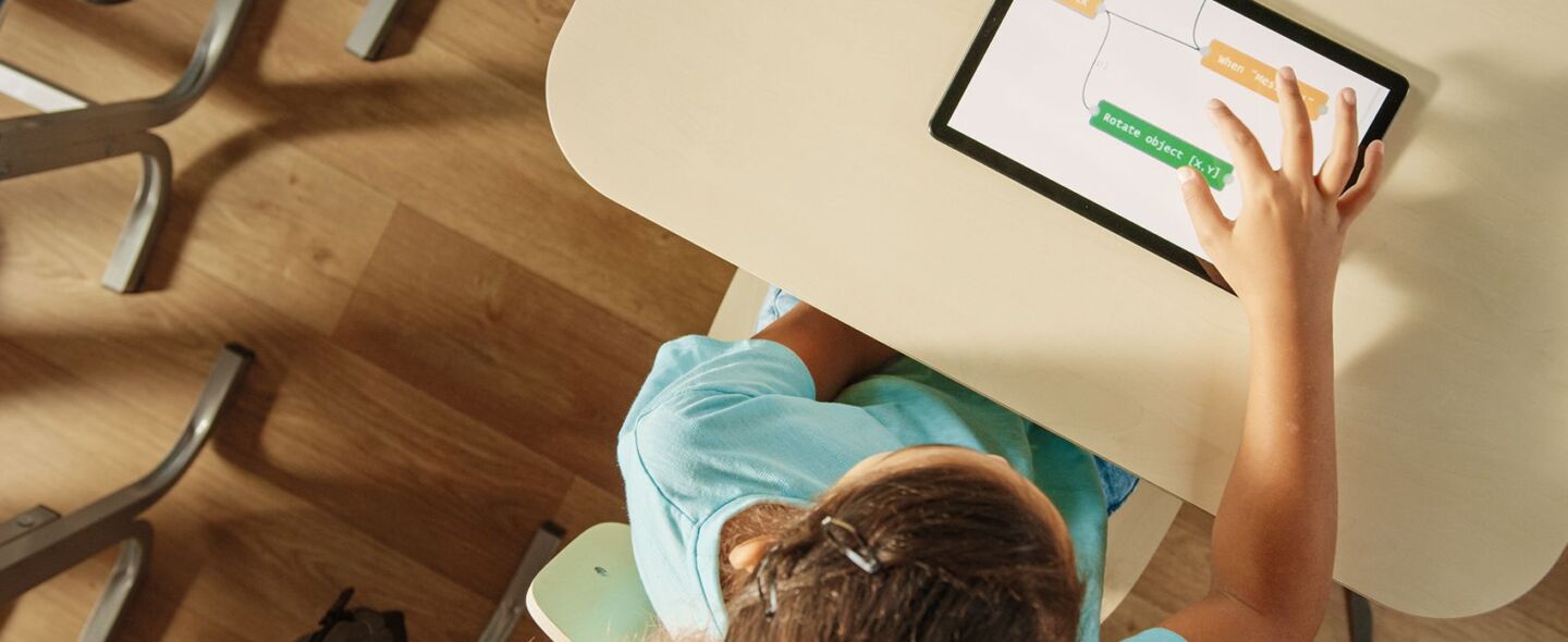 Looking down on a girl working on a tablet