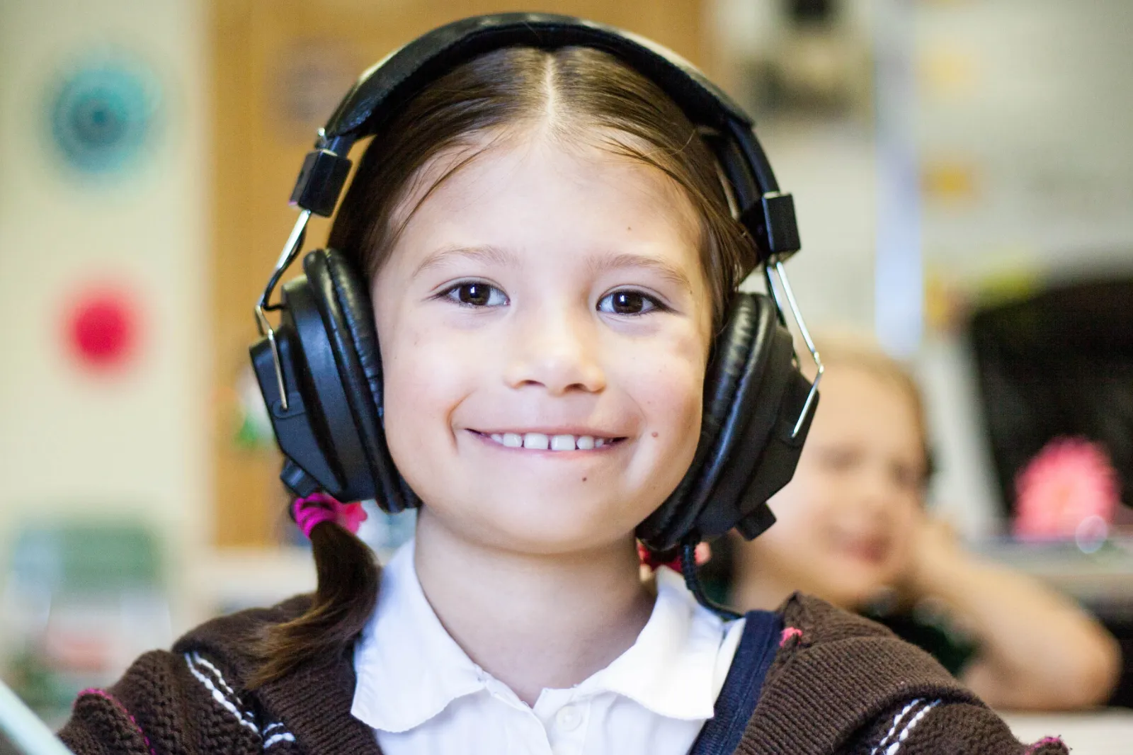 Primary school girl wearing headphones in a lesson