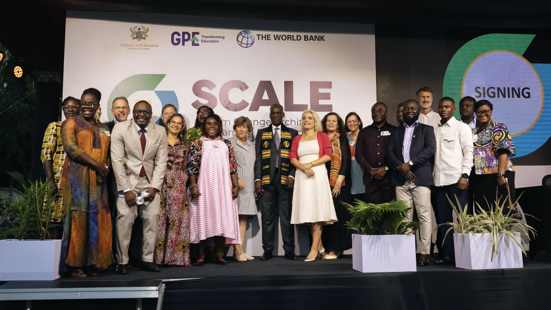 A group of attendees of the SCALE conference standing on a stage in front of the SCALE and partner logos
