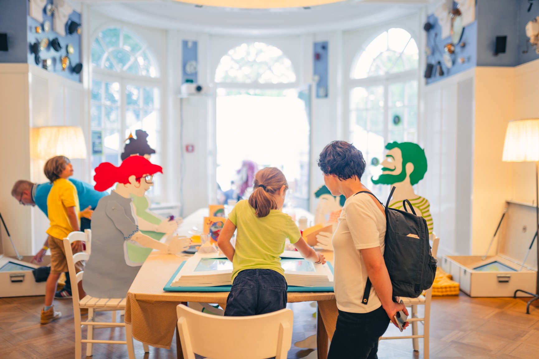 Children are standing around a table while learning.